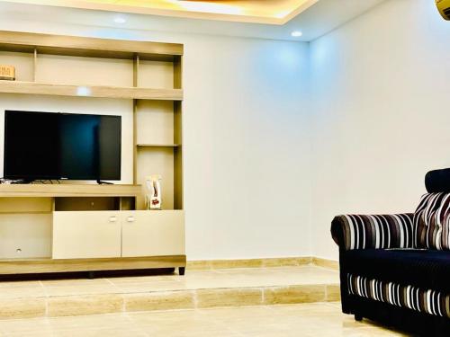 苏尔Atlas Wadi Shab的一间带电视和沙发的客厅