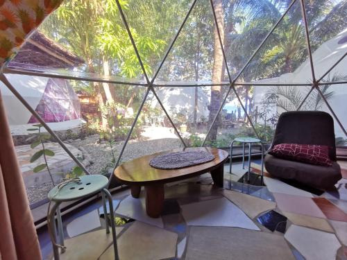 道因Glamping Dome Dauin Beach and Dive Resort的客房设有桌子、椅子和窗户。