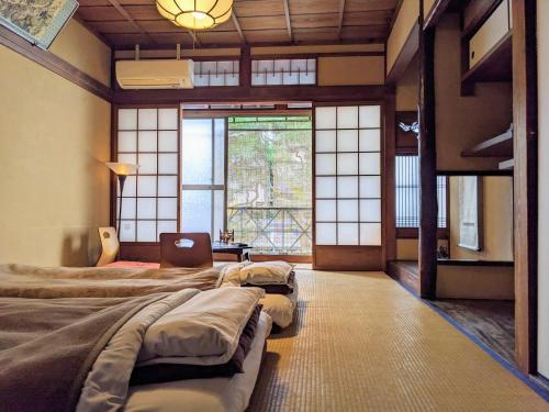 京都Guesthouse itoya Kyoto（京都糸屋旅馆）的带窗户的客房内设有四张床。