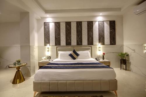 新德里Hotel Transit International- Aerocity Delhi Airport的一间卧室配有一张大床和两张桌子