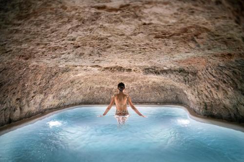 贝尔蒙特El Bálsamo - Hotel Boutique 5 Estrellas的洞穴中游泳池里的一个男人