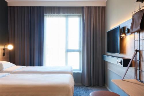 布鲁塞尔Moxy Brussels City Center的酒店客房设有两张床和电视。