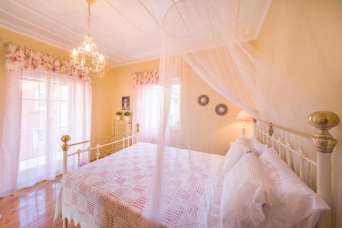 Ágios ProkópiosIoli Traditional Corfu Residence的一间卧室配有一张带天蓬的白色床