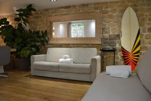巴黎Hot Hot Hot Loft Faubourg Saint-Denis的带沙发和冲浪板的客厅
