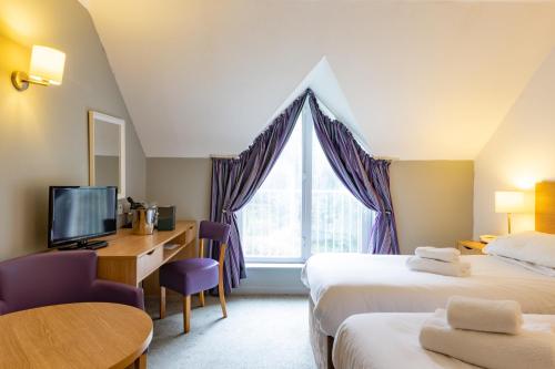 桑当百老汇公园酒店的酒店客房设有两张床、一张书桌和一个窗户。