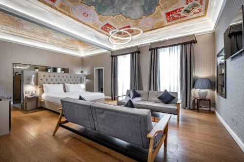 佛罗伦萨Martelli 6 Suite & Apartments的客厅配有床和沙发