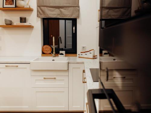 萨图马雷GIA Apartment的厨房配有白色橱柜、水槽和镜子