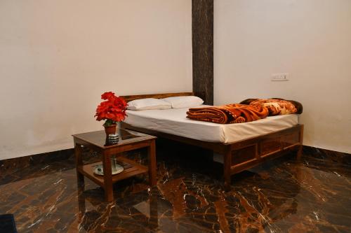 JasidihParadise Inn的一间卧室配有一张床和一张花瓶桌子