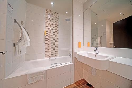 迪拜Premier Inn Dubai Al Jaddaf的白色的浴室设有浴缸和水槽。