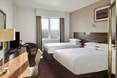 泰恩河畔纽卡斯尔Leonardo Hotel Newcastle的酒店客房设有两张床和电视。