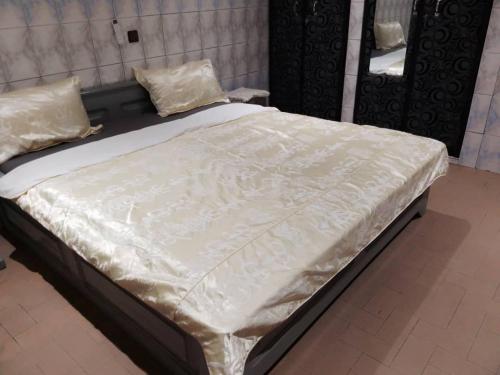 洛美Villa 28的一张带白色床单和枕头的床