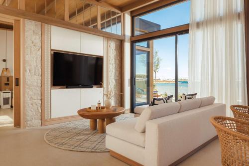 雅典One&Only Aesthesis的客厅配有白色沙发和大窗户