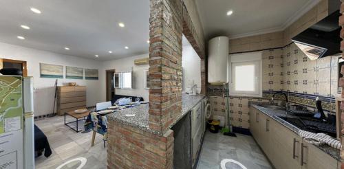 科尼尔-德拉弗龙特拉Apartamento Venus Conil的一间厨房,在房间内配有砖壁炉