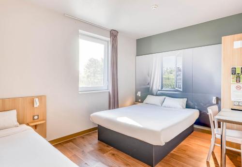 朗贡B&B HOTEL Bordeaux Langon的一间卧室设有两张床和窗户。