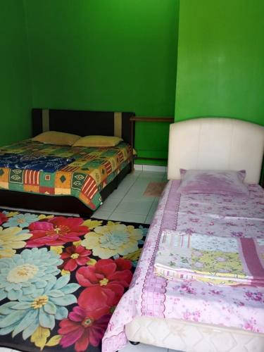 巴佐Pelangi Roomstay的绿墙客房内的两张床