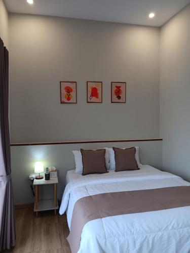 普禾加多44 Guest House Syariah的一间卧室配有两张床和一张带台灯的桌子
