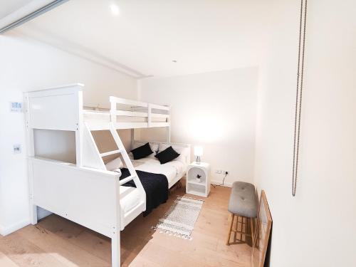 悉尼Cozy Apartment at St Leonard的白色卧室配有双层床和沙发