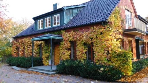 特雷勒堡Minnesberg Bed & Breakfast的蓝色屋顶的常春藤房子