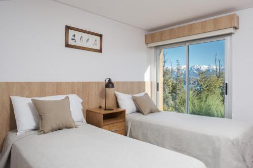 拉安戈斯图拉镇巴伊亚蒙塔纳度假酒店的带窗户的客房内的两张床