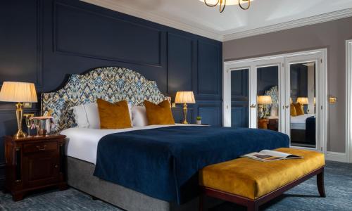 基勒纳德The Heritage的一间卧室配有一张特大号床和蓝色的墙壁