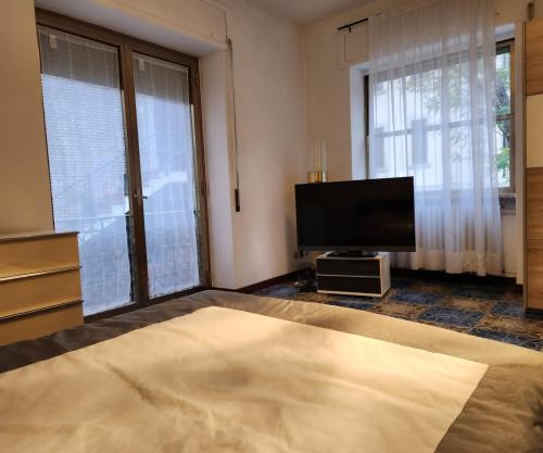 圣马力诺La Famosa Dimora Ambasciatore的客厅配有平面电视和1张床。