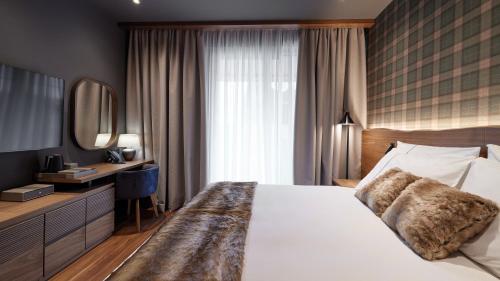 兹拉蒂博尔Bor Hotel by Karisma的卧室配有一张白色大床和镜子