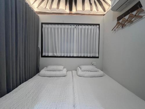 庆州Hanok Dasi Bom 101的一间卧室设有两张床和窗户。