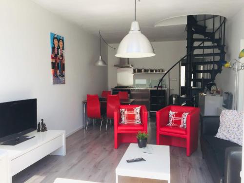 SpakenburgHoliday in Spakenburg Groof的客厅配有红色椅子和沙发