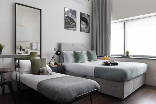 海斯廷斯Vive Hotel的一间卧室设有两张床、一张桌子和一个窗口。