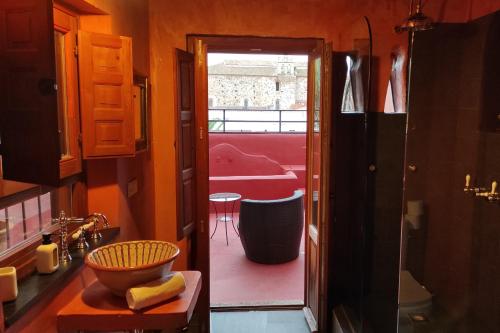 卡塞雷斯波希米亚酒店的浴室设有通往红色房间的门