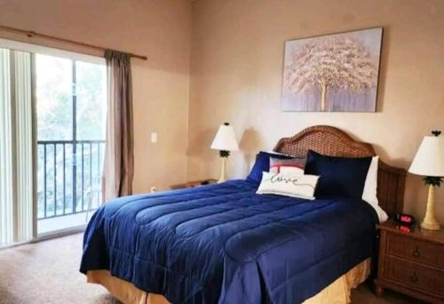 基西米Bahama Bay Resort & Spa - Deluxe Condo Apartments的一间卧室设有蓝色的床和窗户。