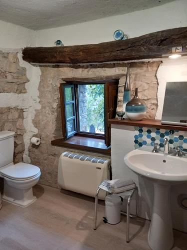AgninoSotto il fico的一间带水槽和卫生间的浴室以及窗户。