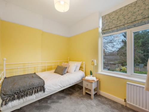 曼彻斯特Pass the Keys Large 4 Bed House with Games Room的黄色的卧室设有床和窗户