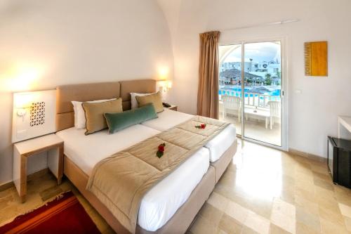 乌姆苏克Djerba Sun Beach, Hotel & Spa的一间带大床的卧室和一个阳台
