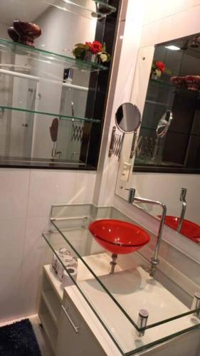 贝伦Loft em Belém的浴室玻璃柜台上的红色凳子