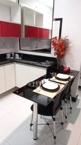 贝伦Loft em Belém的厨房配有红色和白色的橱柜以及桌椅