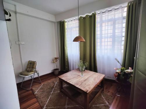 大吉岭Ivory Botanic Stay的客厅配有木桌和绿色窗帘
