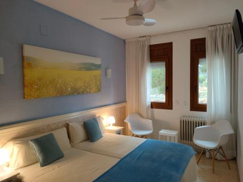 罗列特海岸皮纳莱斯旅馆的一间卧室配有一张蓝色墙壁和窗户的床