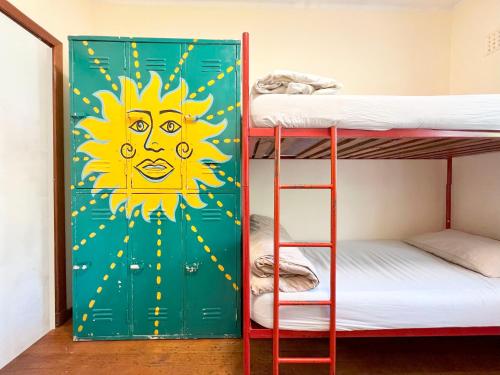 开普敦Long Street Backpackers的一个带双层床的房间,一扇有阳光的大门
