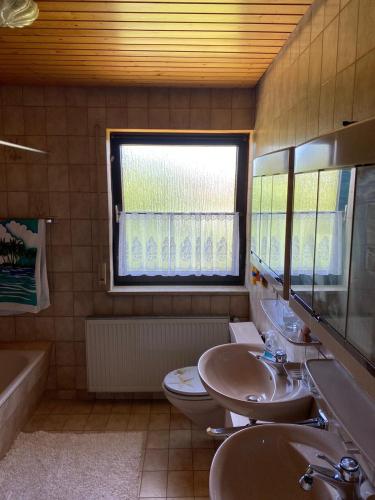 施瓦格明德Alex的一间带两个盥洗盆、卫生间和窗户的浴室