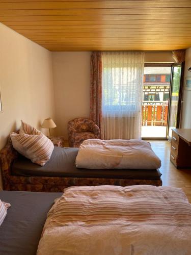 施瓦格明德Alex的酒店客房,配有两张床和椅子