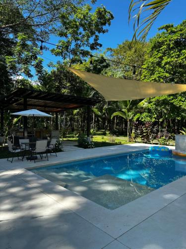 BarrigonesLa Amapola Lodge, Bungalow en Península de Osa.的游泳池配有太阳伞和桌椅