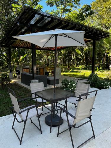 BarrigonesLa Amapola Lodge, Bungalow en Península de Osa.的庭院内桌椅和遮阳伞