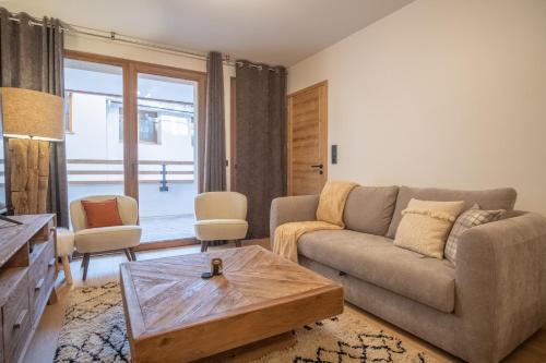 于埃Charming three-room apartment in Huez - Welkeys的带沙发和咖啡桌的客厅