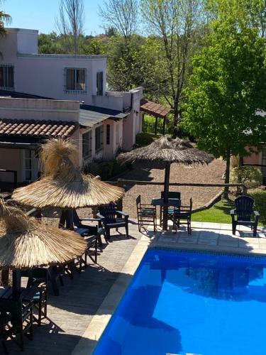 科隆卡瓦尼亚斯普马燕山林小屋的一座带椅子和遮阳伞的游泳池位于一座建筑旁边