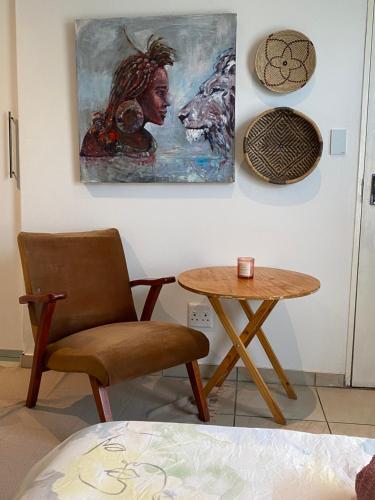 温特和克Nambani House的一间房间,配有椅子、桌子和绘画