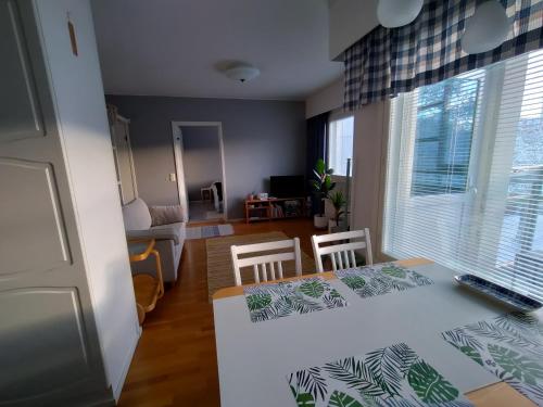 拉彭兰塔Viihtyisä kaksio ydinkeskustassa的厨房以及带桌椅的起居室。