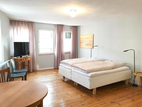 葡萄酒之路上的诺伊施塔特Fuxbau的一间卧室配有一张床、一张桌子和一台电视