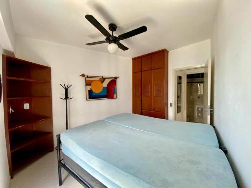 卡拉瓜塔图巴APTO DE FRENTE PARA O MAR - CARAGUATATUBA.的一间卧室配有一张床和吊扇