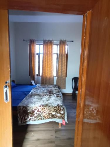 西姆拉Him Aaranya Home stay Shimla的一间卧室设有一张床和两个窗户。